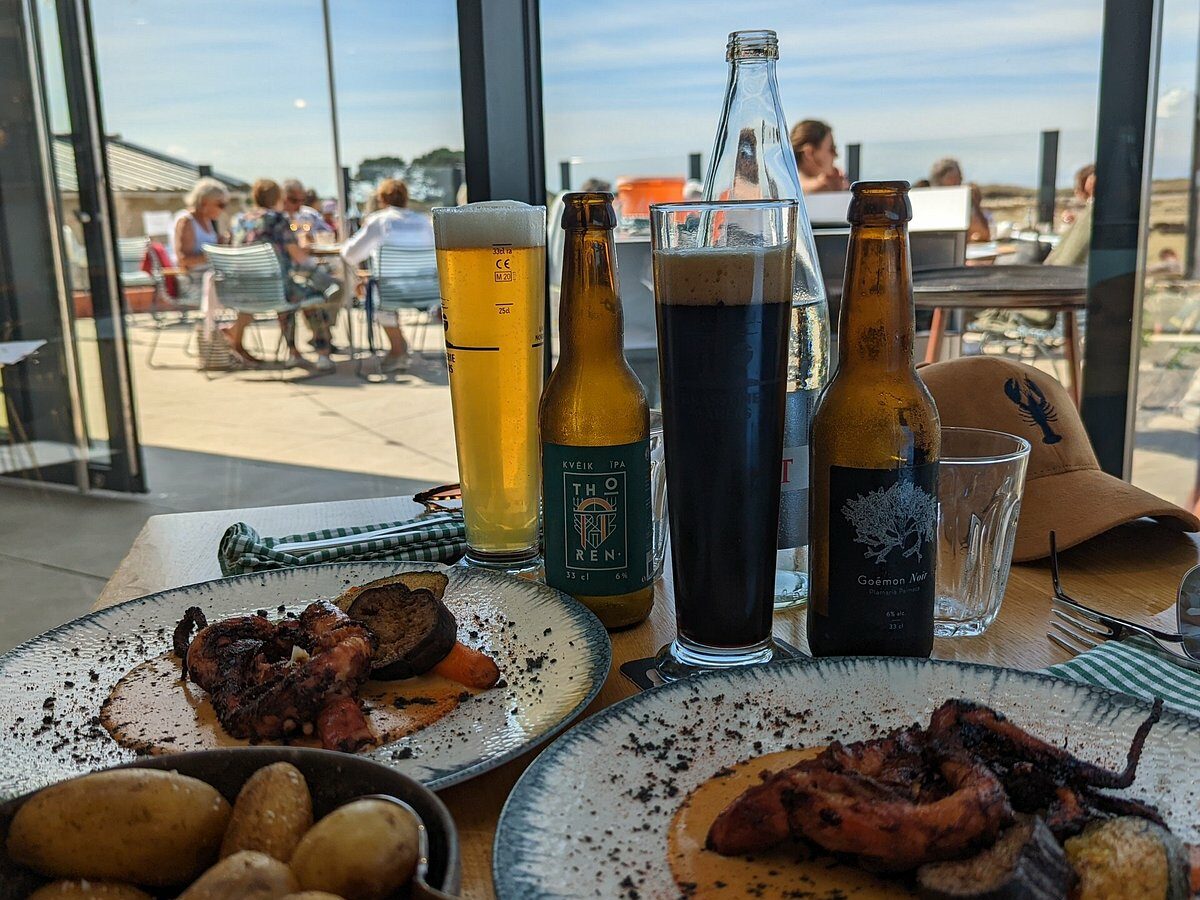 À Lilia, Mémé Lilia propose une cuisine familiale dans un établissement ouvert sur la mer. Le restaurant met en avant les producteurs locaux, les légumes d’un maraîcher biologique et les poissons fraîchement pêchés par le Labous Mor II, bateau visible face à l’établissement.

L’adresse ne se limite pas aux plateaux de fruits de mer. Elle convient davantage aux voyageurs qui souhaitent découvrir une cuisine travaillée autour des arrivages, des poissons et des saveurs marines, dans une ambiance contemporaine mais conviviale.

Le lieu associe une terrasse minérale tournée vers la mer et un espace intérieur aux matières plus chaleureuses. La carte pouvant évoluer selon les saisons et la pêche, il est préférable de la consulter avant de réserver.

À choisir pour : un repas cuisiné autour du poisson, une atmosphère moderne et une vue sur le littoral de Lilia.